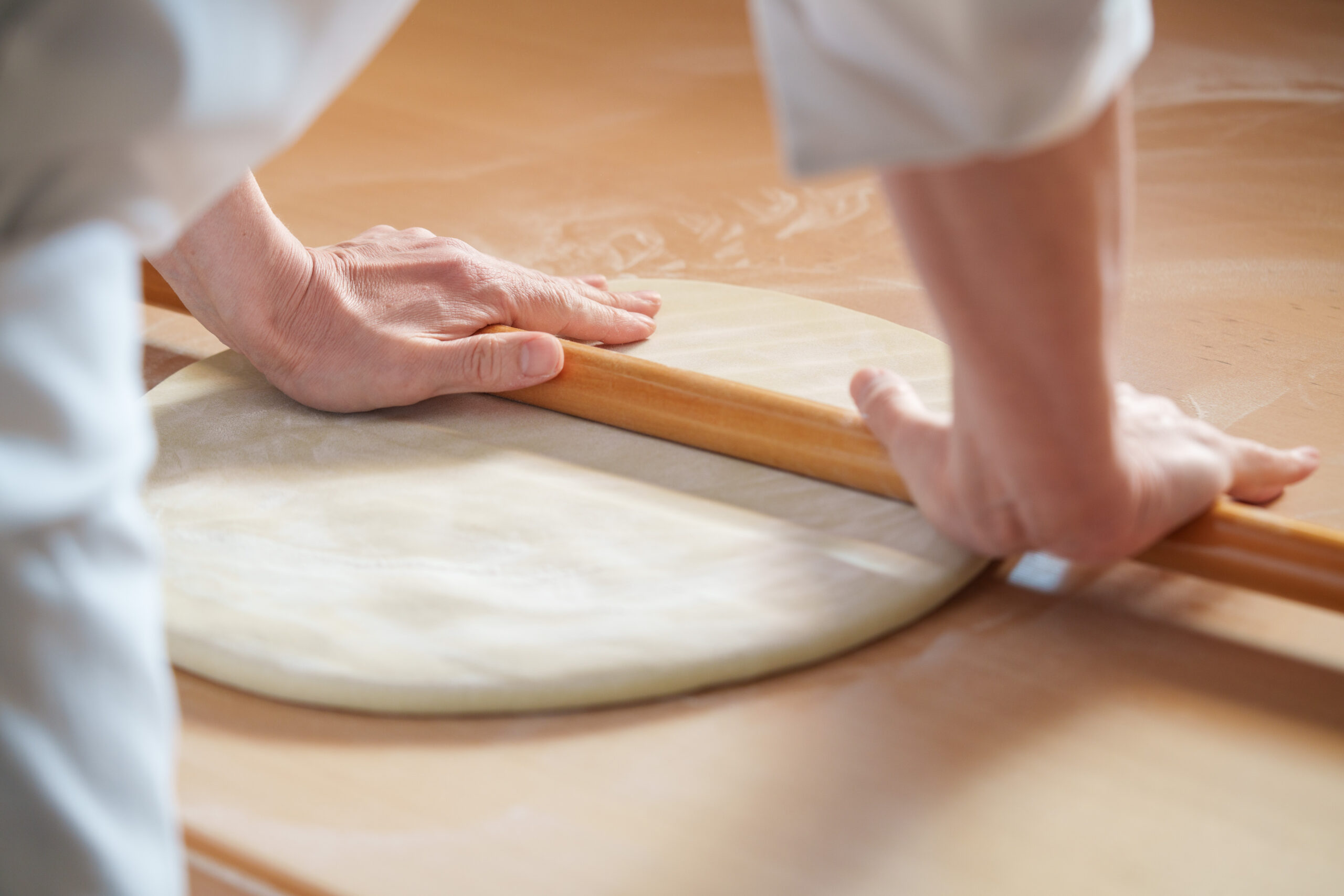 蕎麦を綿棒で伸ばしている様子